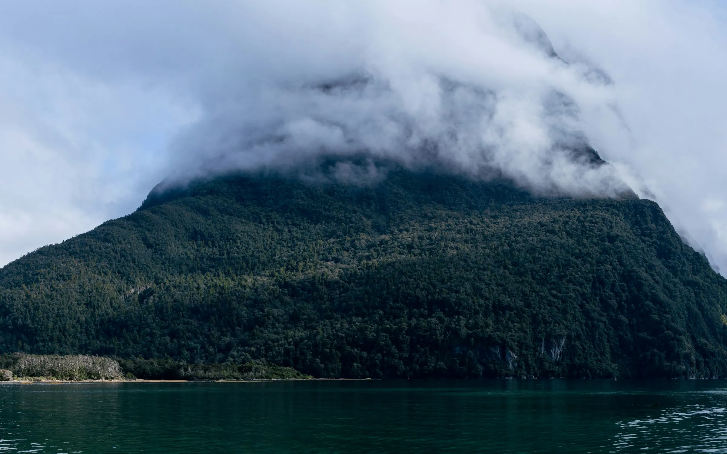 Mountains reflected in the still water of Milford Sound, New Zealand