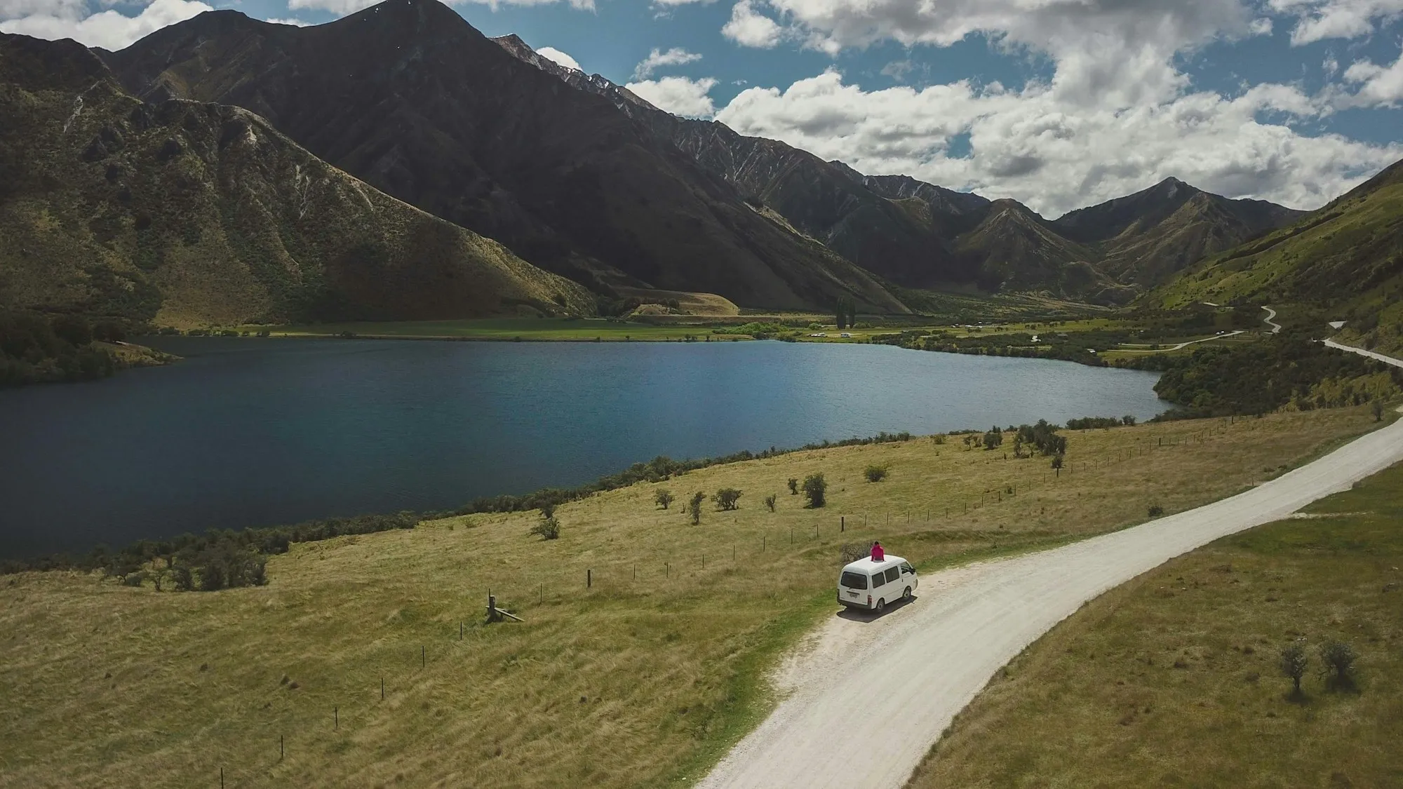 Car on a New Zealand road beside a lake